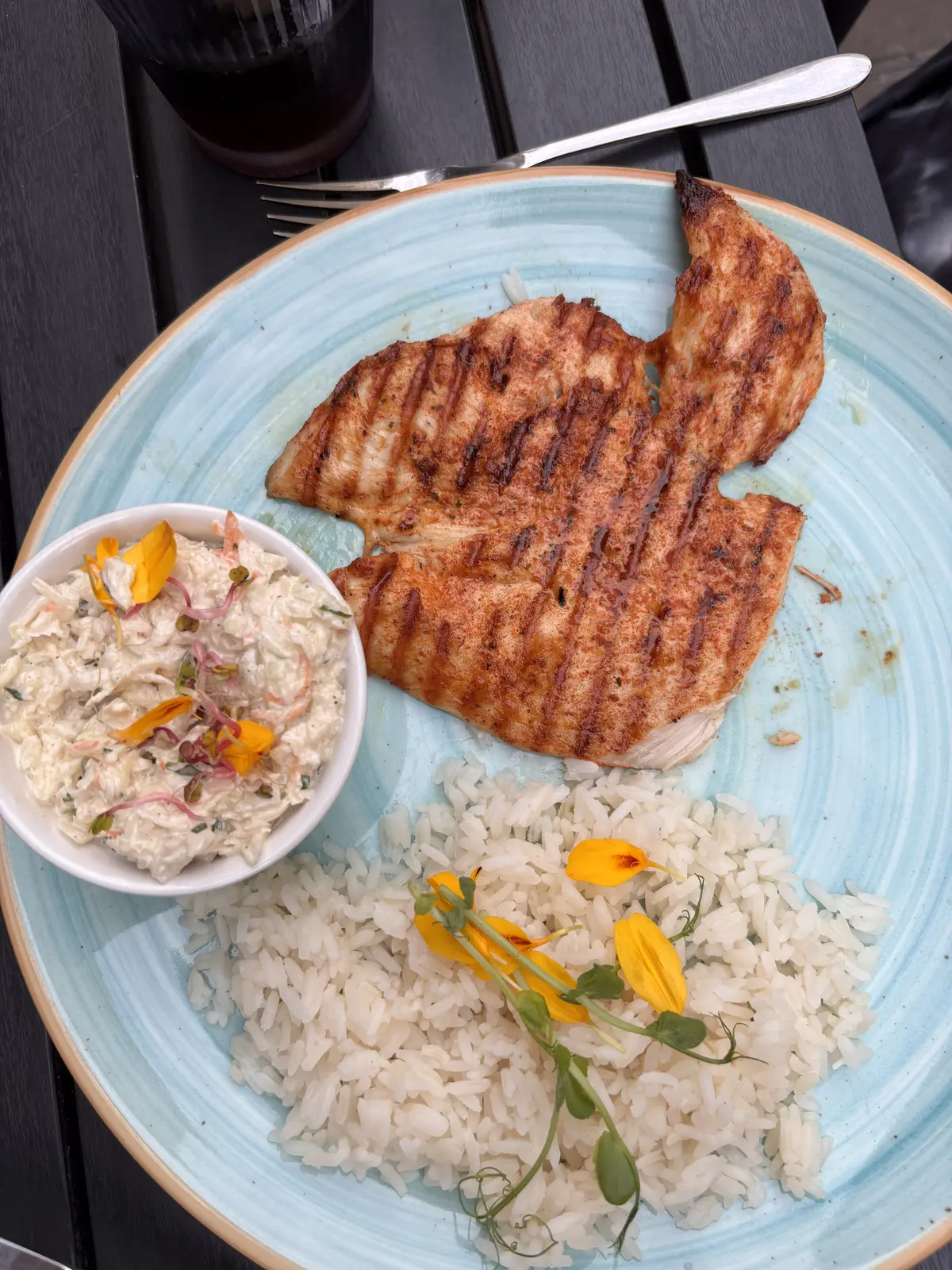 Un filet de poulet grillé, riz et salade coleslaw, servi chez Domowe Przysmaki à Cracovie