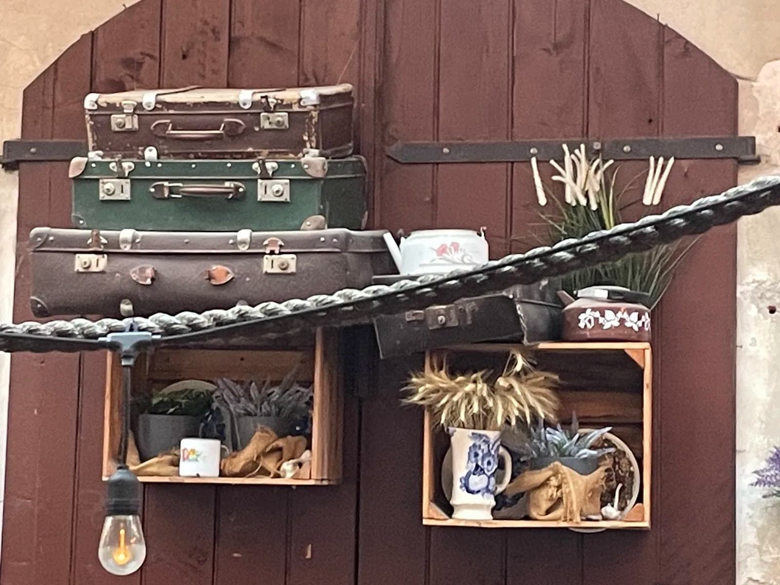 Valises anciennes et objets suspendus dans une cour décorée de Kazimierz, Cracovie