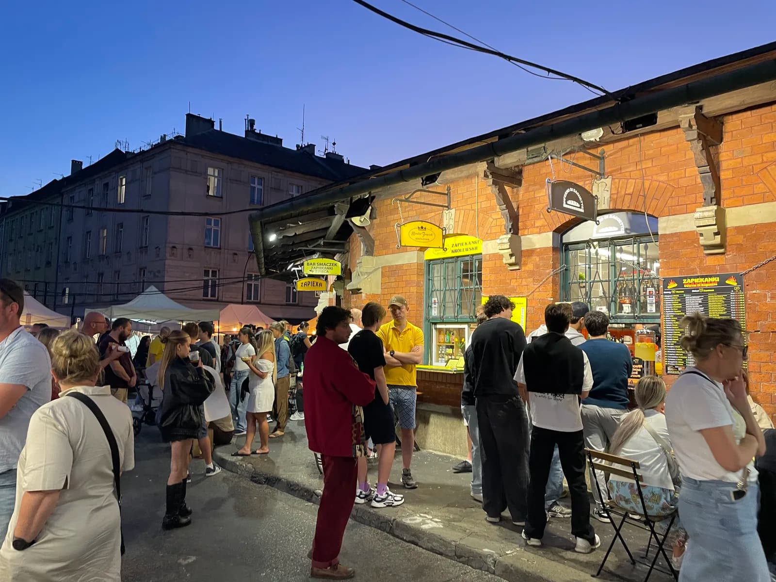 La foule devant les comptoirs de street food de la place Nowy, le soir, Cracovie