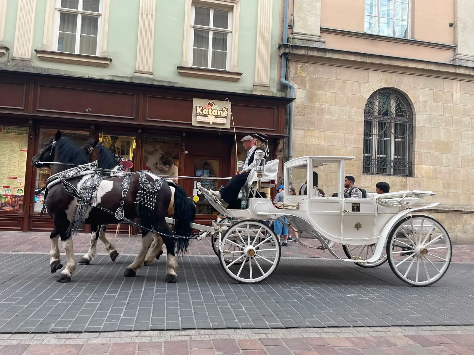 Une calèche blanche dans la vieille ville de Cracovie