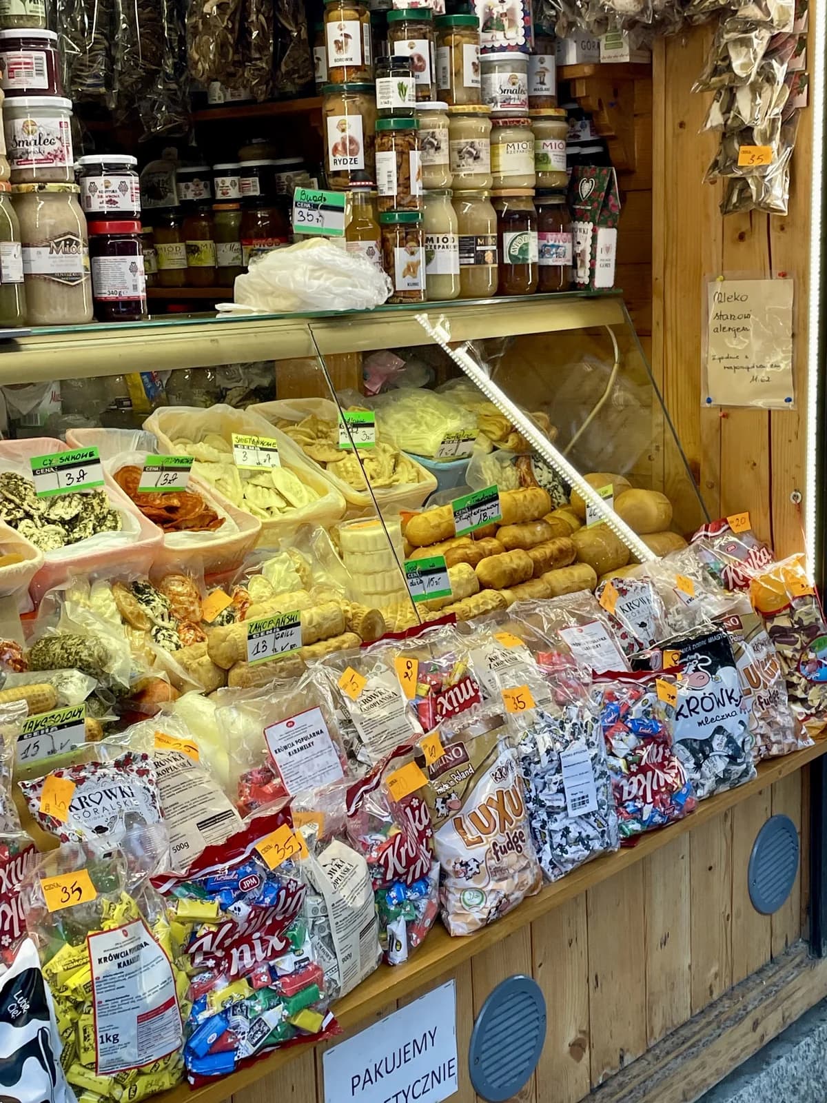 Étal de spécialités locales rue Krupówki : oscypek, miels, confitures, krówki et pierogi