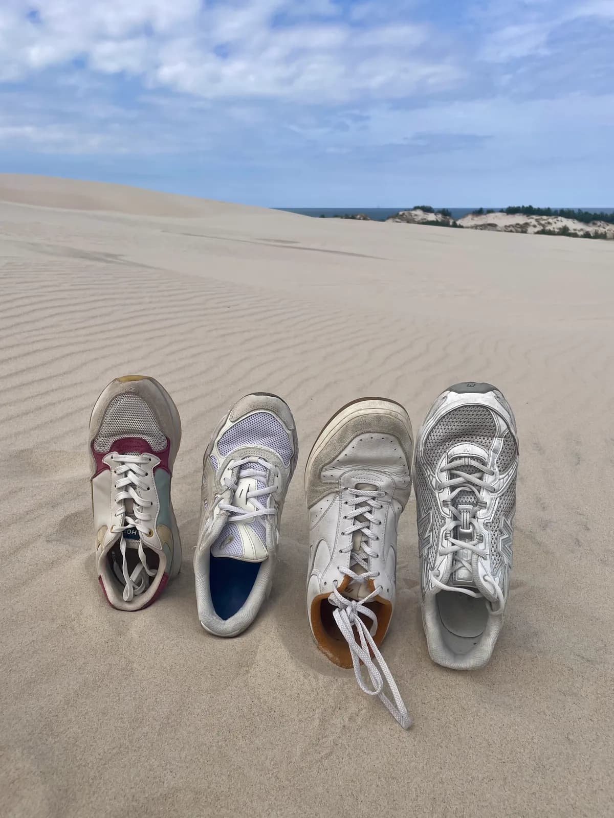 Les baskets de toute la famille plantées dans le sable, lors de notre road trip en Pologne