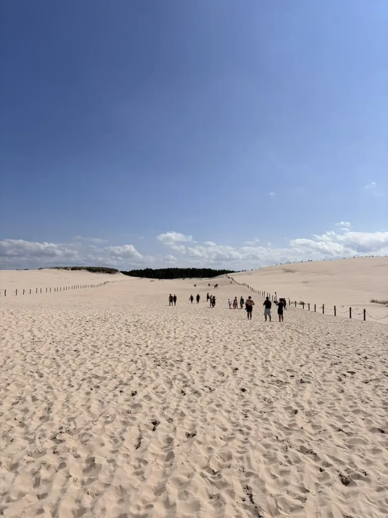 Randonneurs sur le sentier balisé de la dune mouvante de Łącka