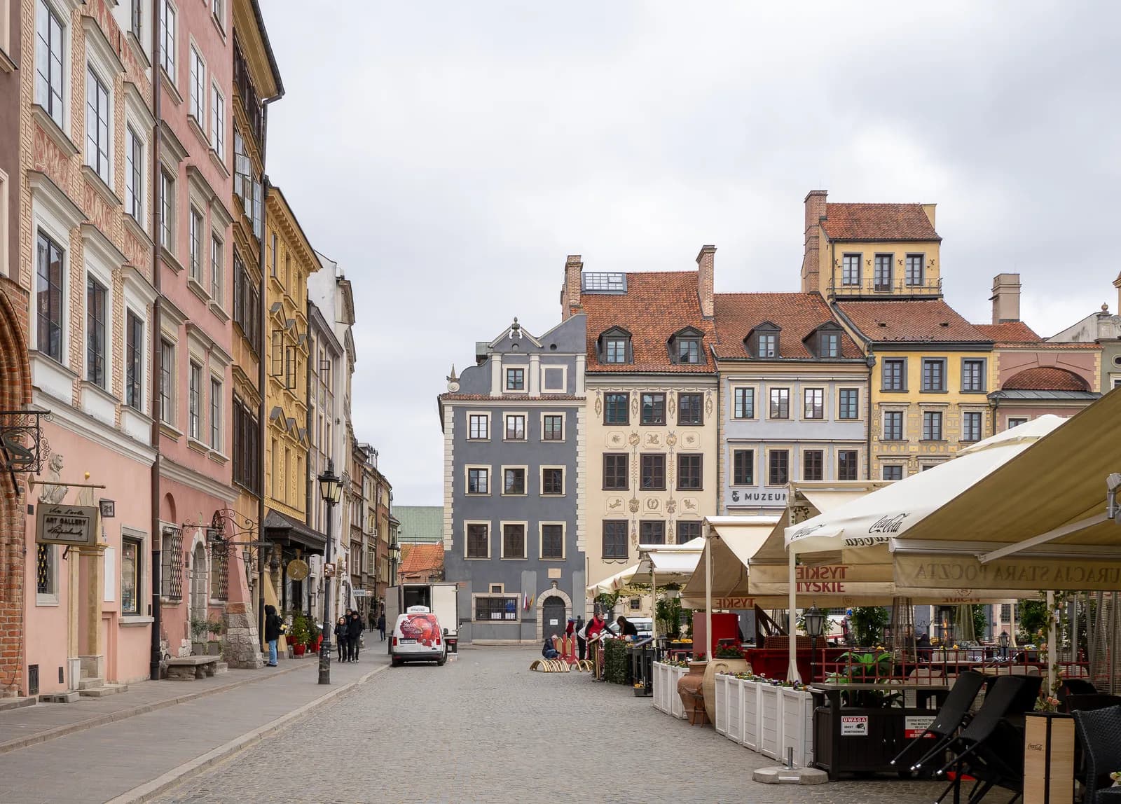 Une rue pavée de la vieille ville de Varsovie, bordée de façades reconstruites